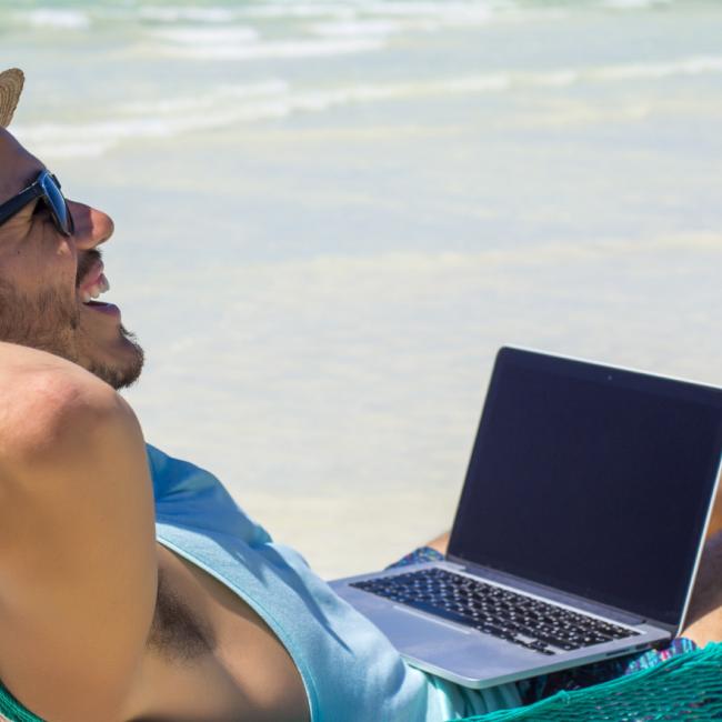 Nomade numérique travaillant sur la plage